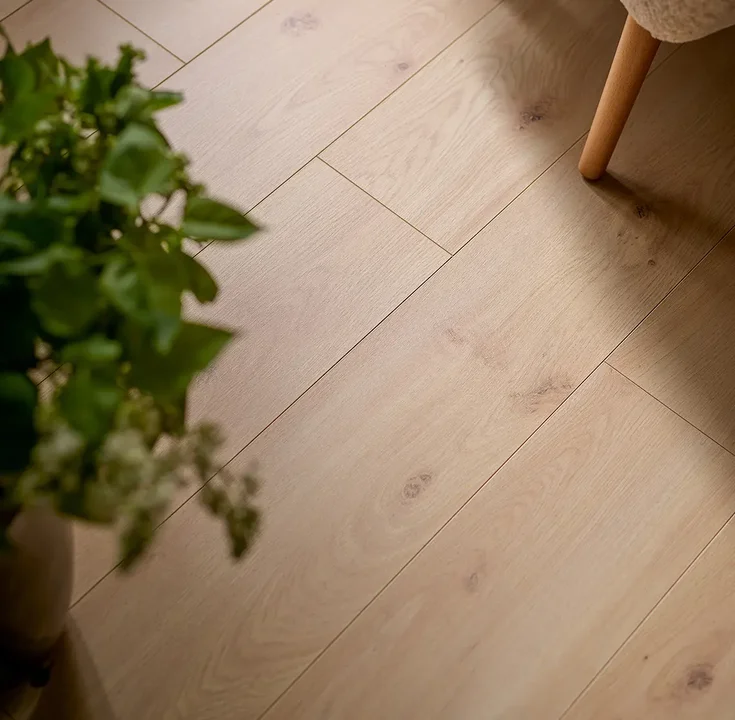 Naturalne jasne panele podłogowe w minimalistycznym wnętrzu z roślinami.
